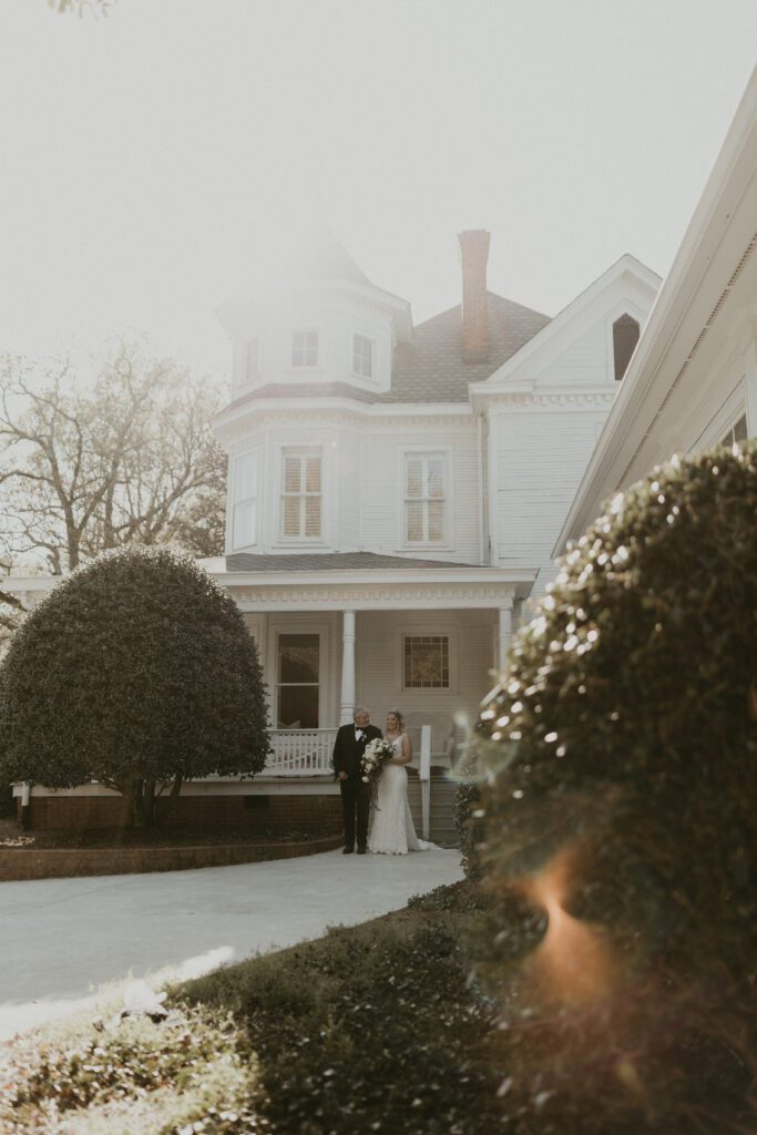 Film inspired photo of bride and her dad outside the mansion interacting before the wedding ceremony.