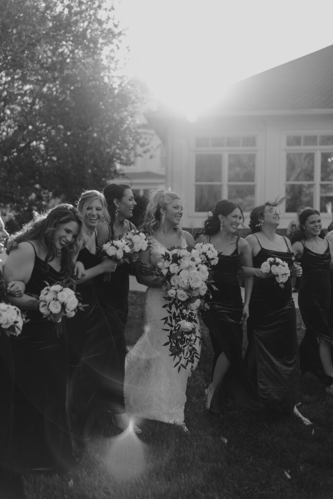 Documentary style photo of bride and bridesmaids laughing and walking
