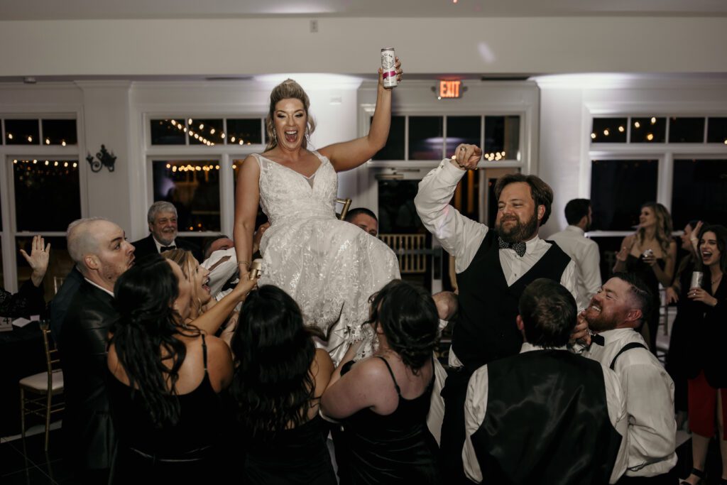 bride and groom lifted on chairs at reception
