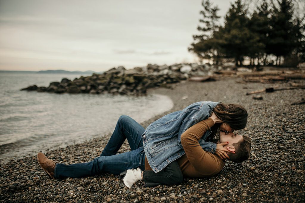 couple kissing during their romantic engagement session on alki beach
