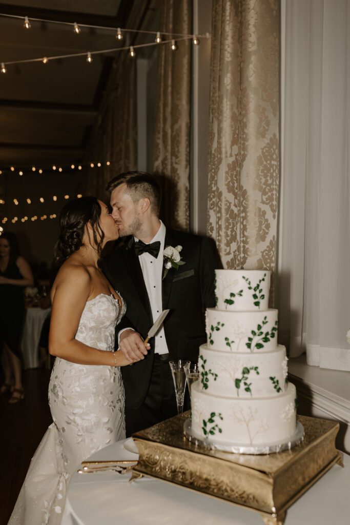 bride-and-groom-cutting-their-three-tiered-botanical-inspired-wedding-cake