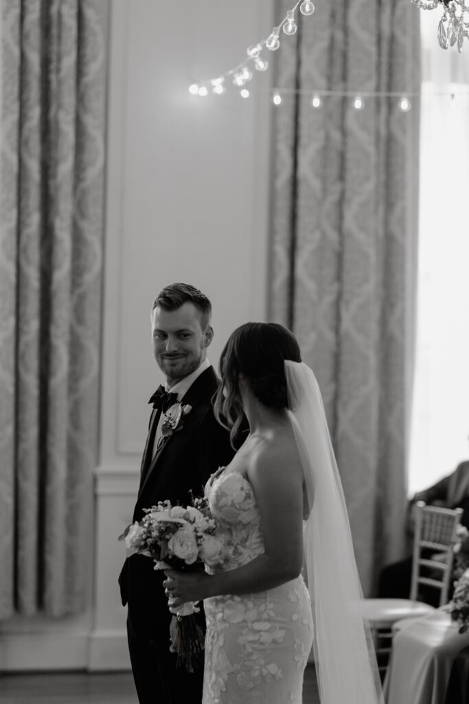 groom-smiling-at-bride-in-front-of-the-altar