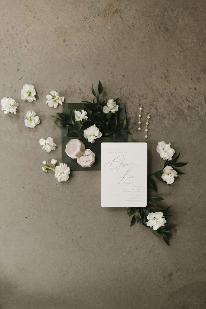 wedding-flatlay-with-minimalist-invitations-and-green-envelope