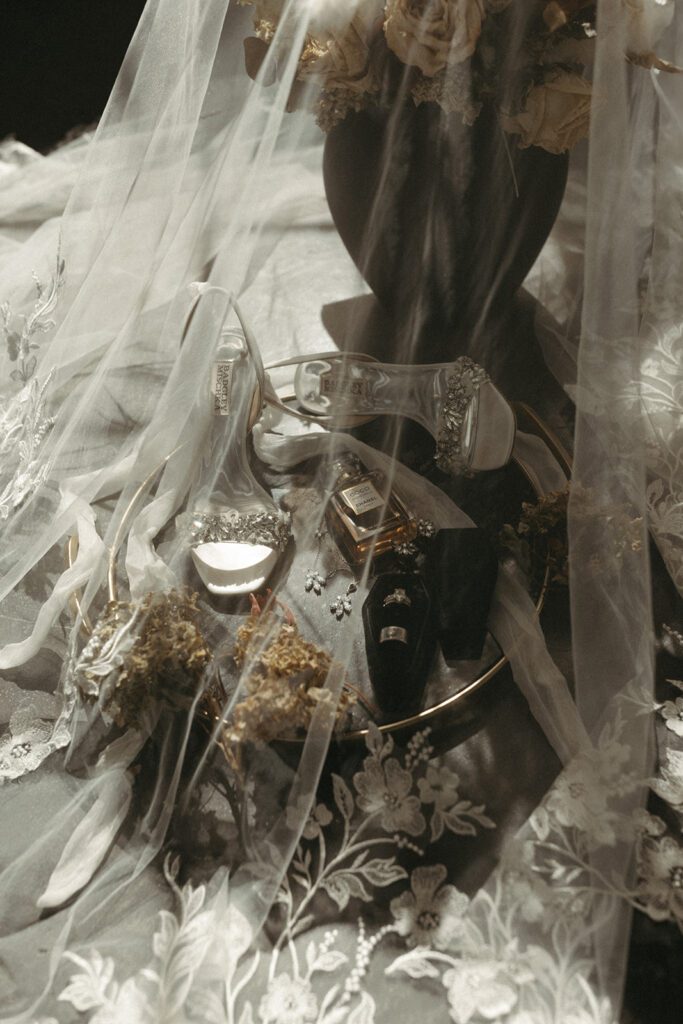 modern-friday-the-13th-wedding-flatlay-with-jewel-tones-dried-florals-badgley-mischka-heels-under-the-veil