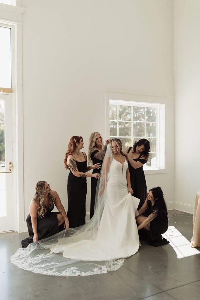 bridesmaids-in-all-black-help-bride-get-ready-for-their-ivory-barn-wedding
