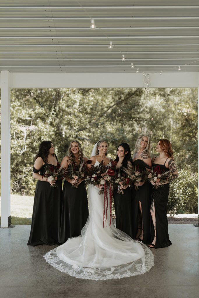 bridesmaids-in-mismatched-black-satin-dresses-and-jewel-toned-boquets