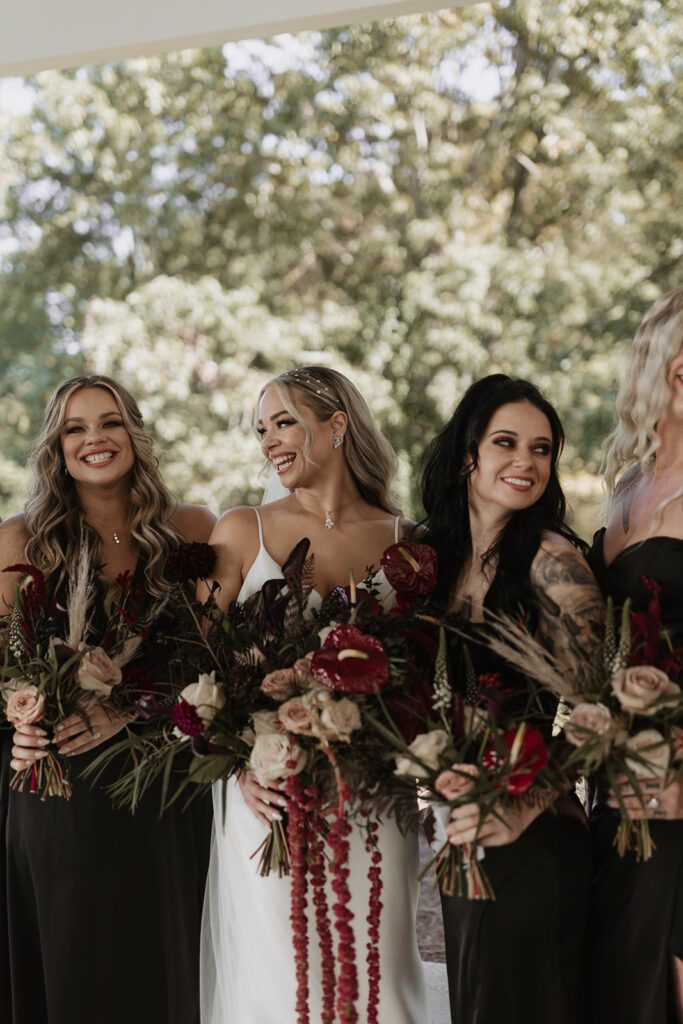 bridesmaids-in-mismatched-black-satin-dresses-and-jewel-toned-boquets