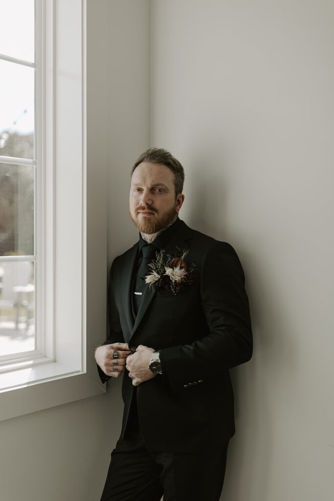 indoor-groom-portrait-by-the-window-with-pocket-florals
