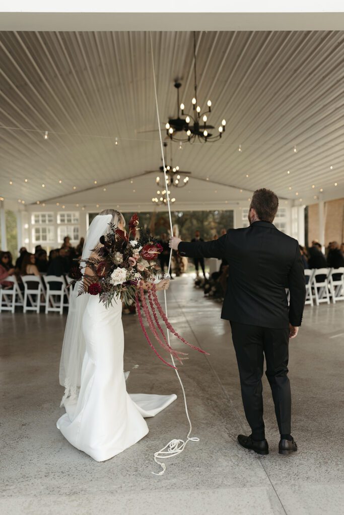 bride-and-groom-ringing-the-bell-at-the-ivory-barn-after-their-wedding-ceremony