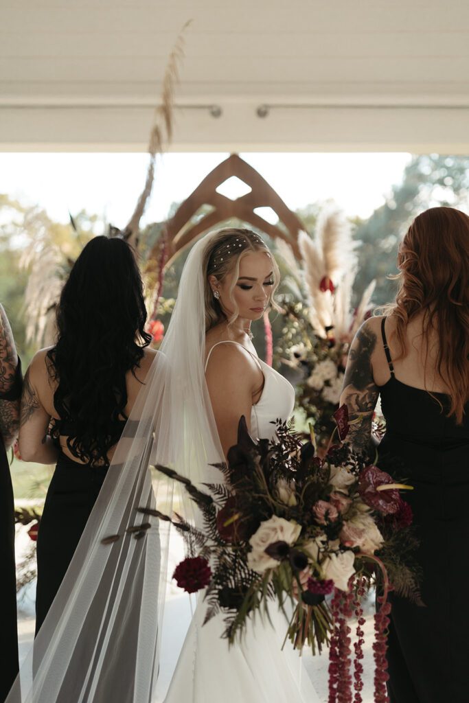 bridesmaids-in-mixmatched-black-satin-dresses-and-jewel-toned-bouquets