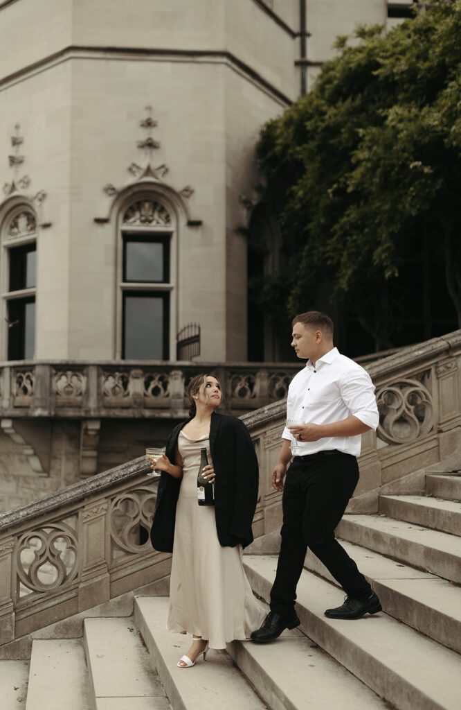 couple-sipping-champagne-on-the-steps-at-their-glam-biltmore-estate-engagement-session