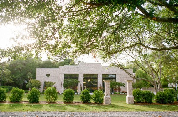 exterior of the wrightsville manor, a white brick wedding venue with expansive gardens