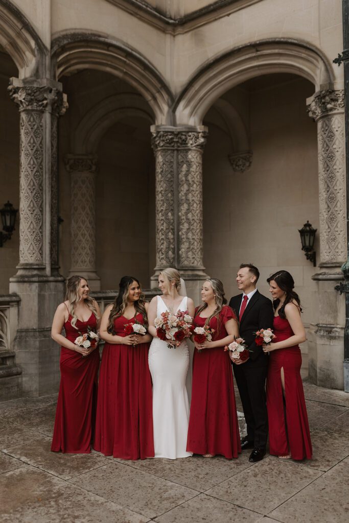 red bridesmaid dresses with organic bouquets in front of the Biltmore estate wedding venue