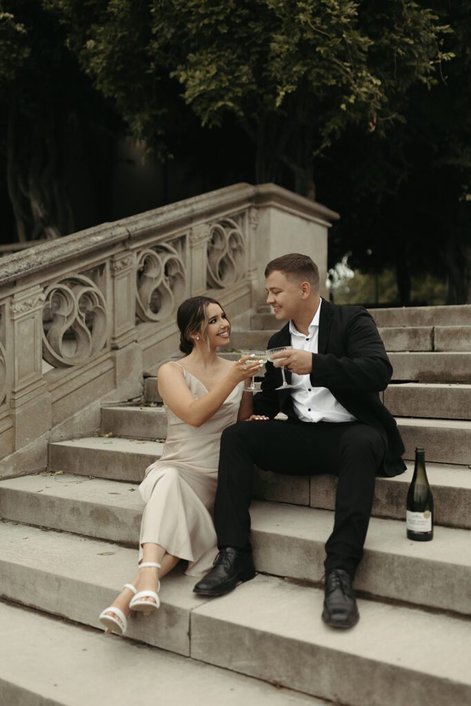 slip dress engagement photos with champagne coupes on the mansion stairs