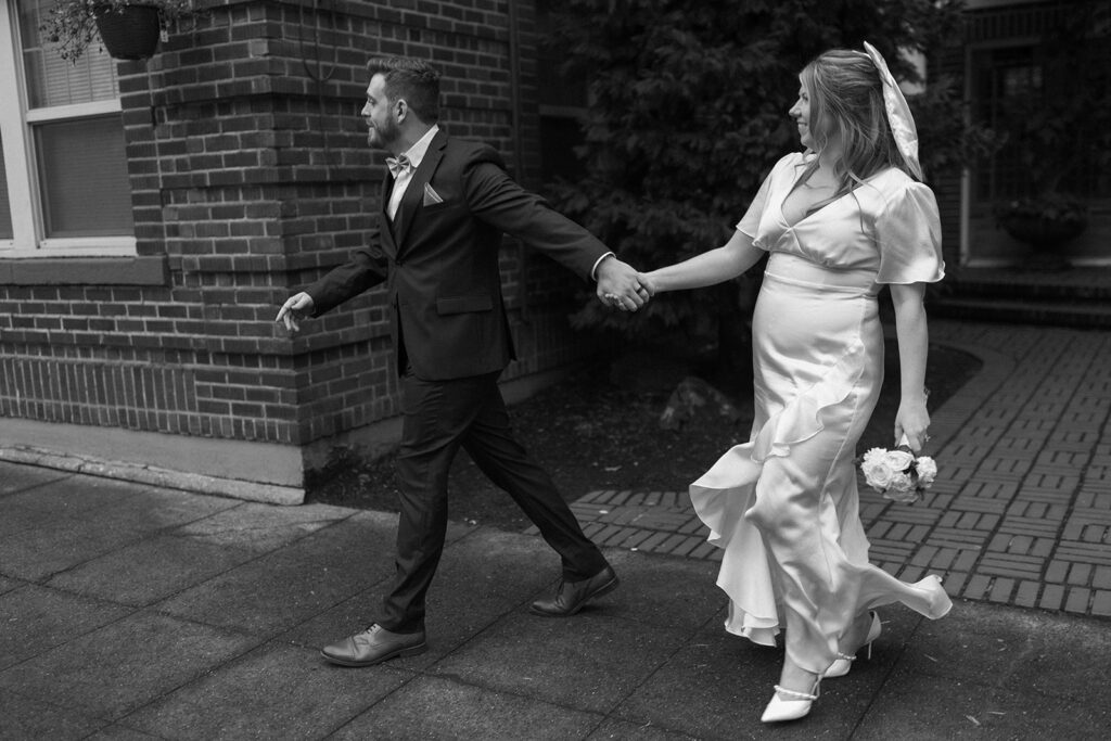 bride and groom running through downtown seattle after their elopement